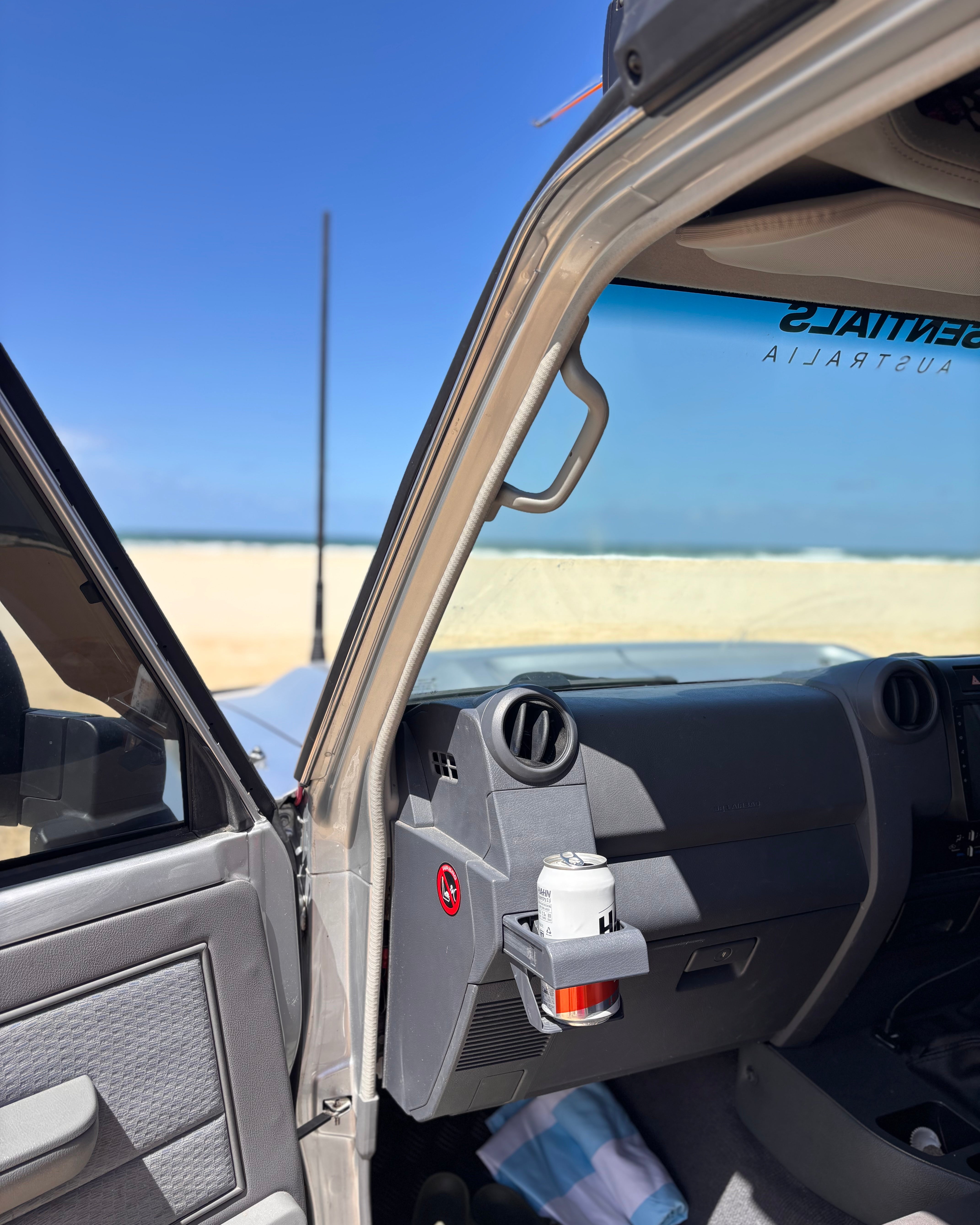 70 Series Land Cruiser on the beach with a door open and cup holder