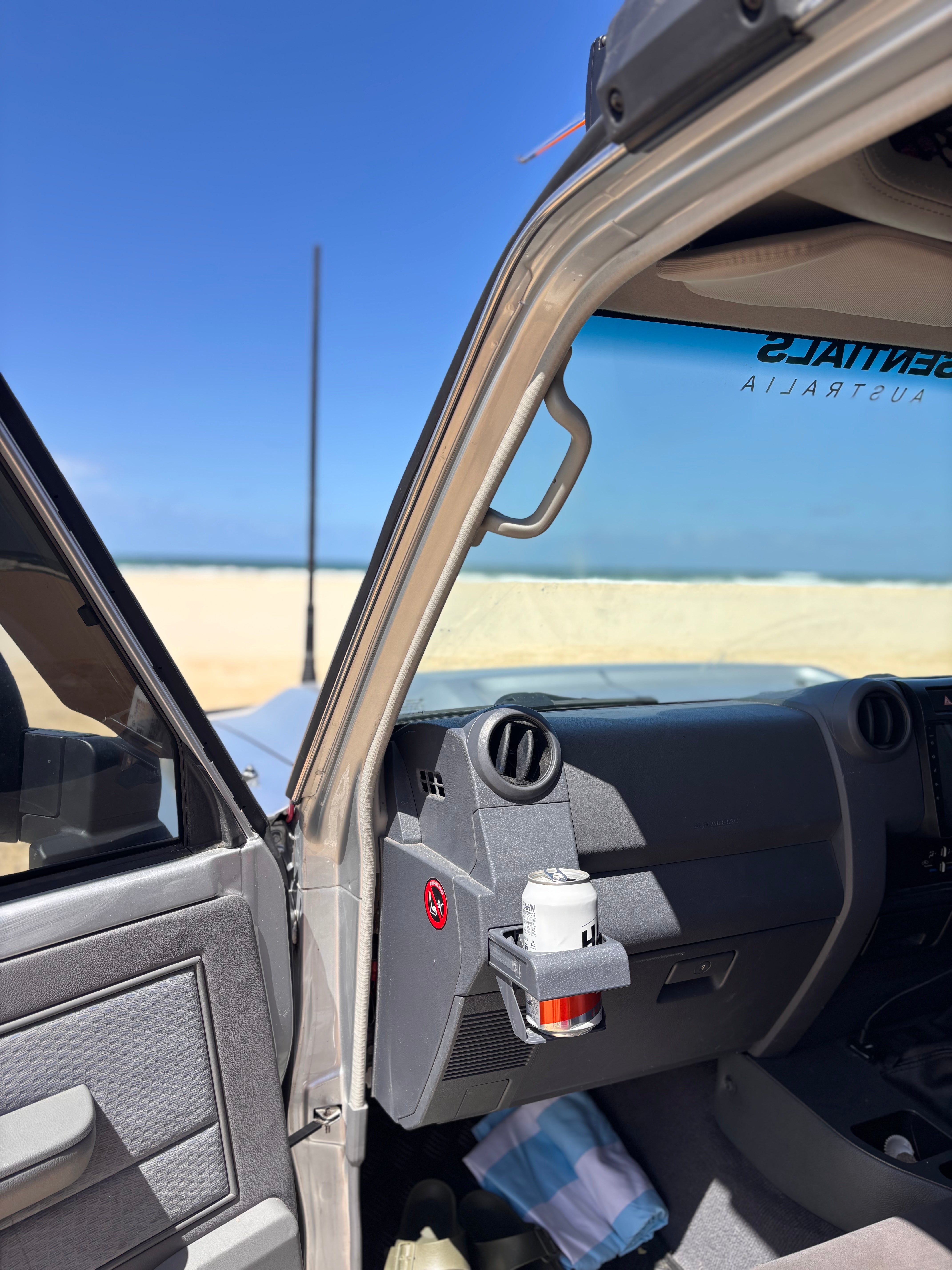 70 Series Land Cruiser on the beach with a door open and cup holder
