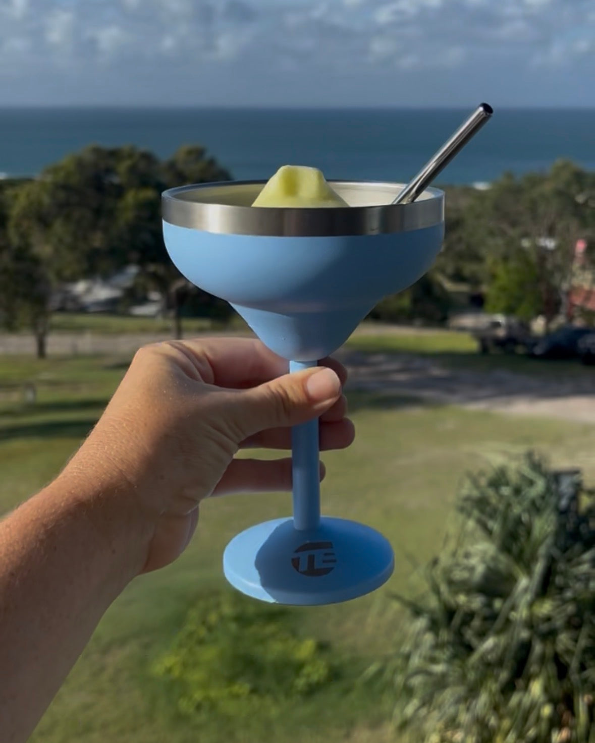Insulated cocktail cup with straw at the beach