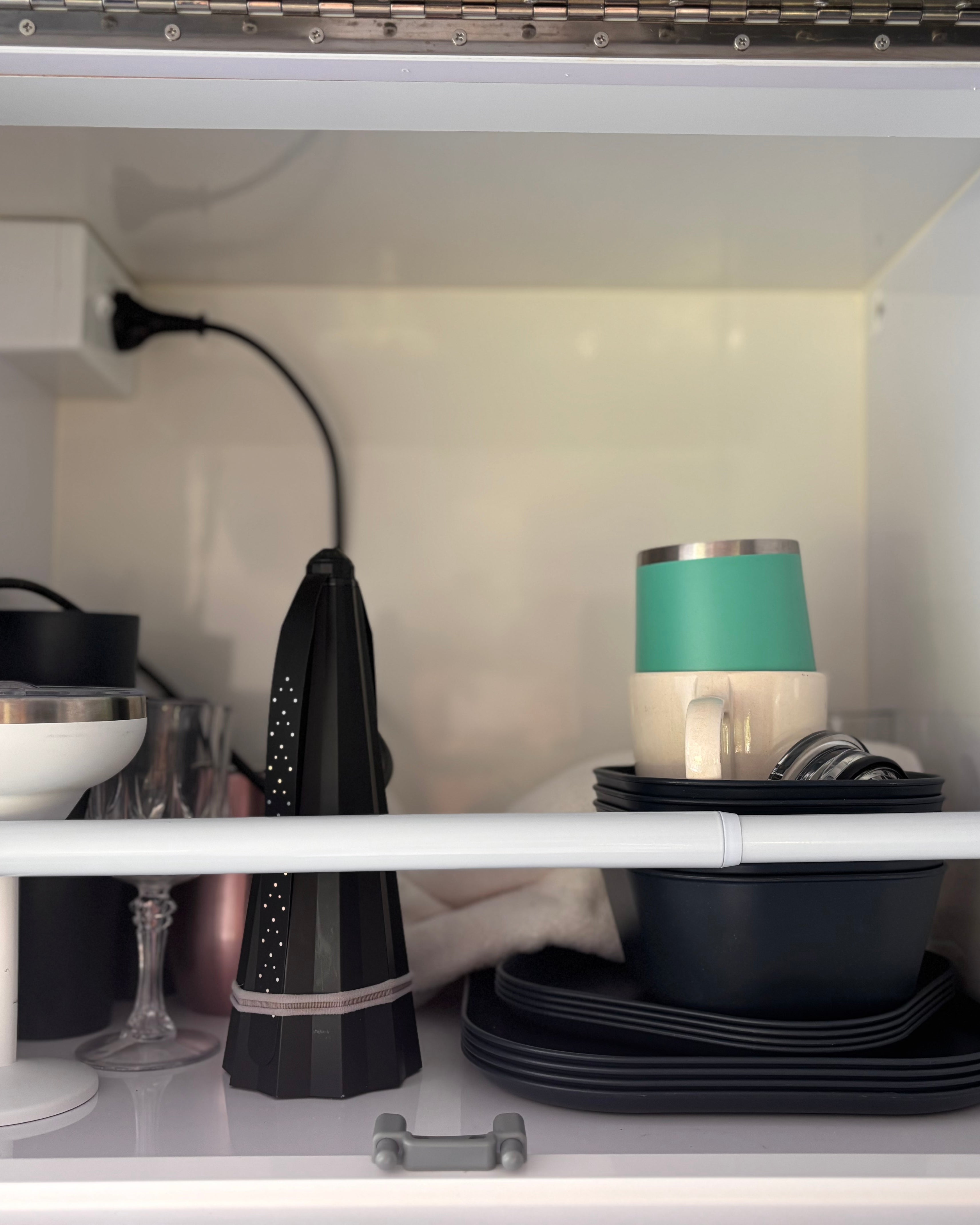 a cupboard with cups, plates and a protector