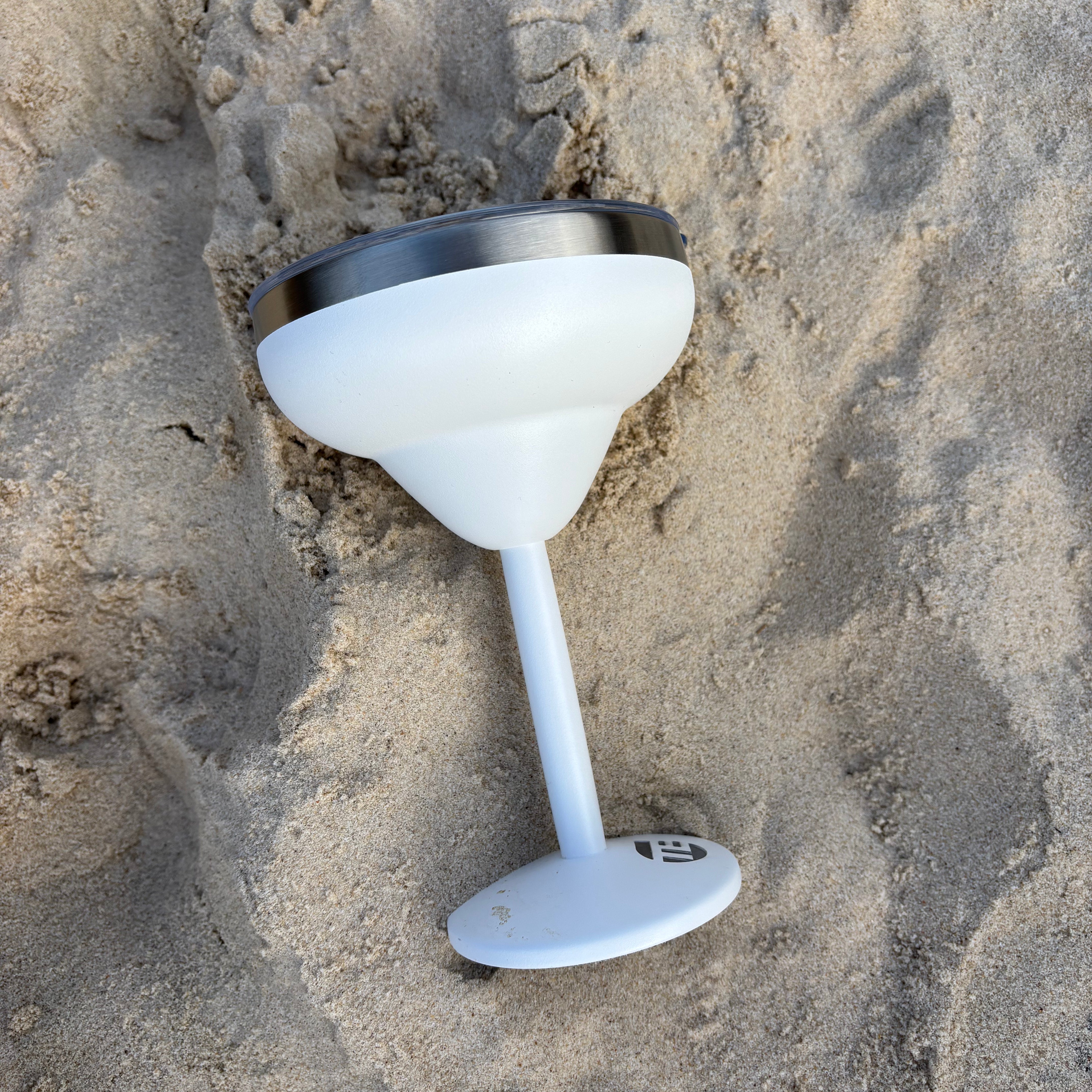 white insulated cocktail cup on sand