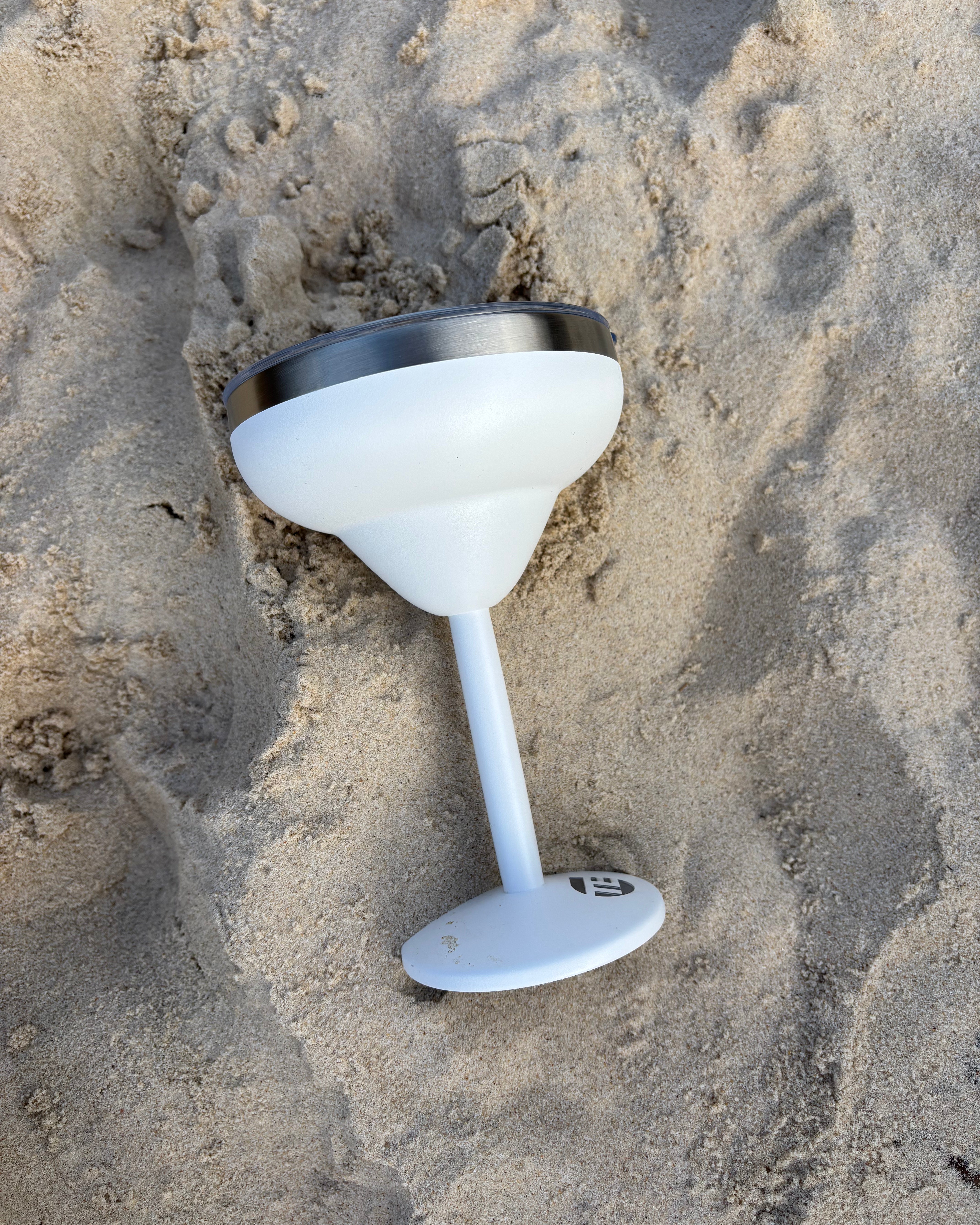 white insulated cocktail cup on sand