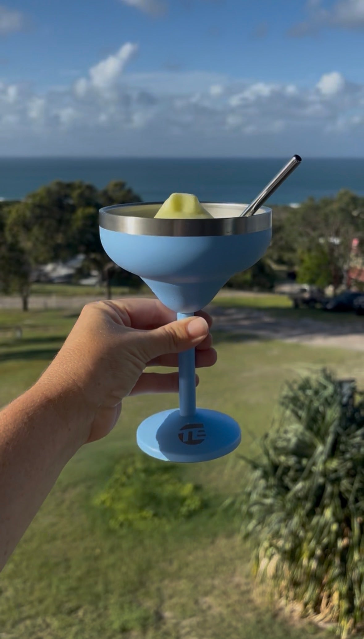 Insulated cocktail cup with straw at the beach