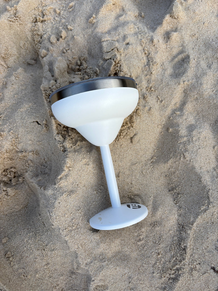 white insulated cocktail cup on sand